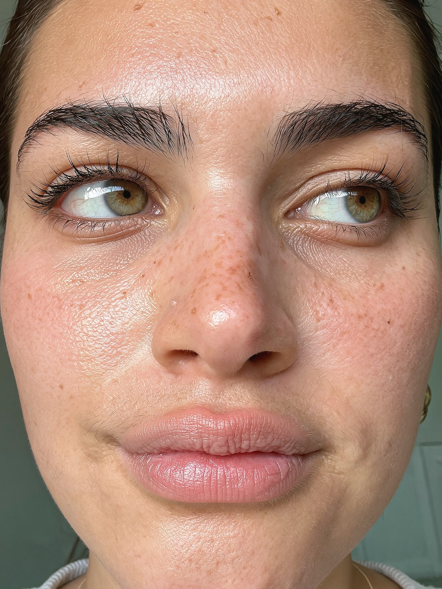 Close-up portrait showing natural pores, eyelashes and fine facial texture