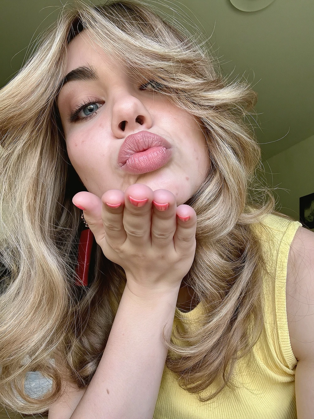 Playful blonde portrait blowing a kiss